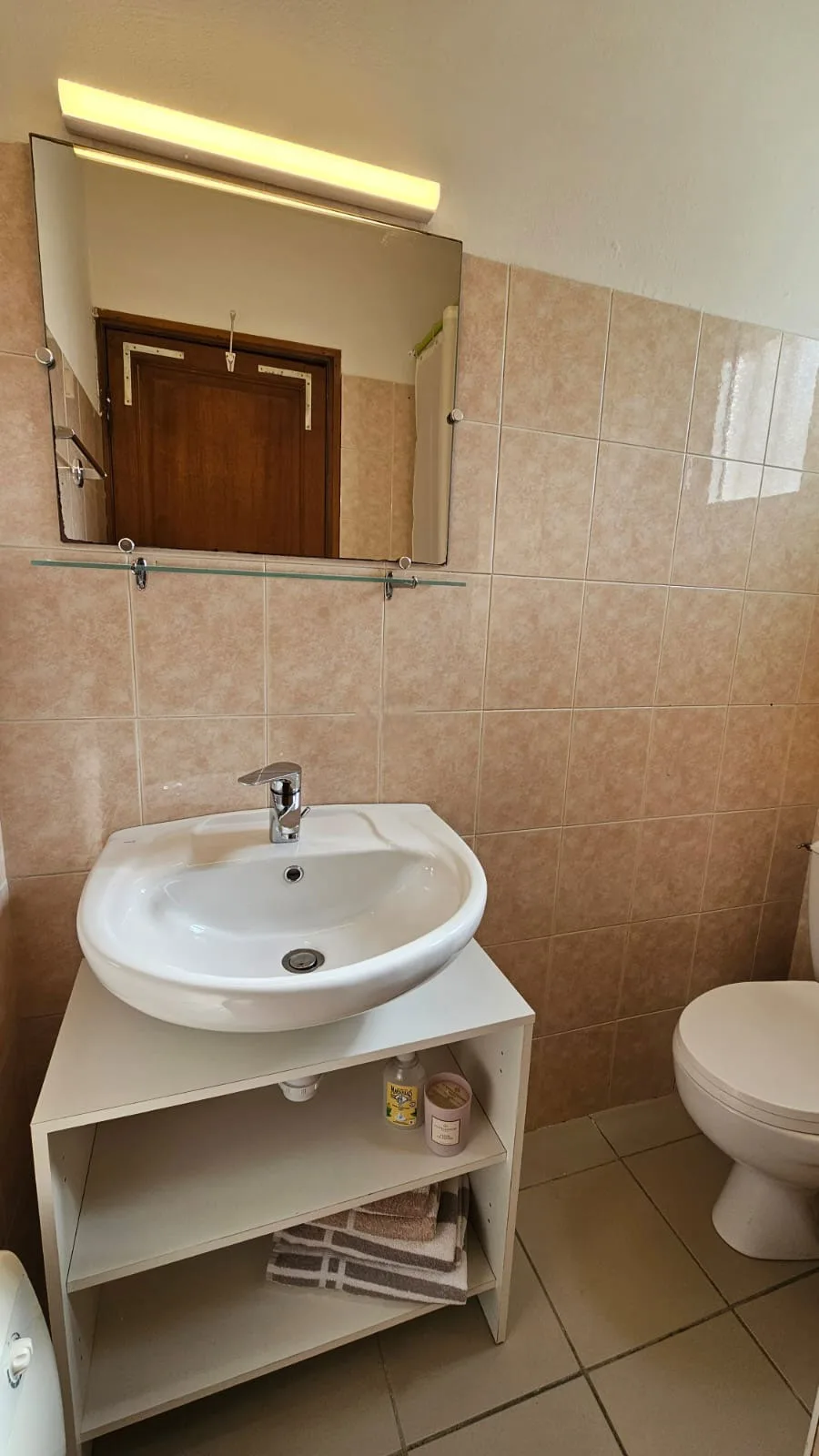 Salle de bain privative avec lavabo et miroir