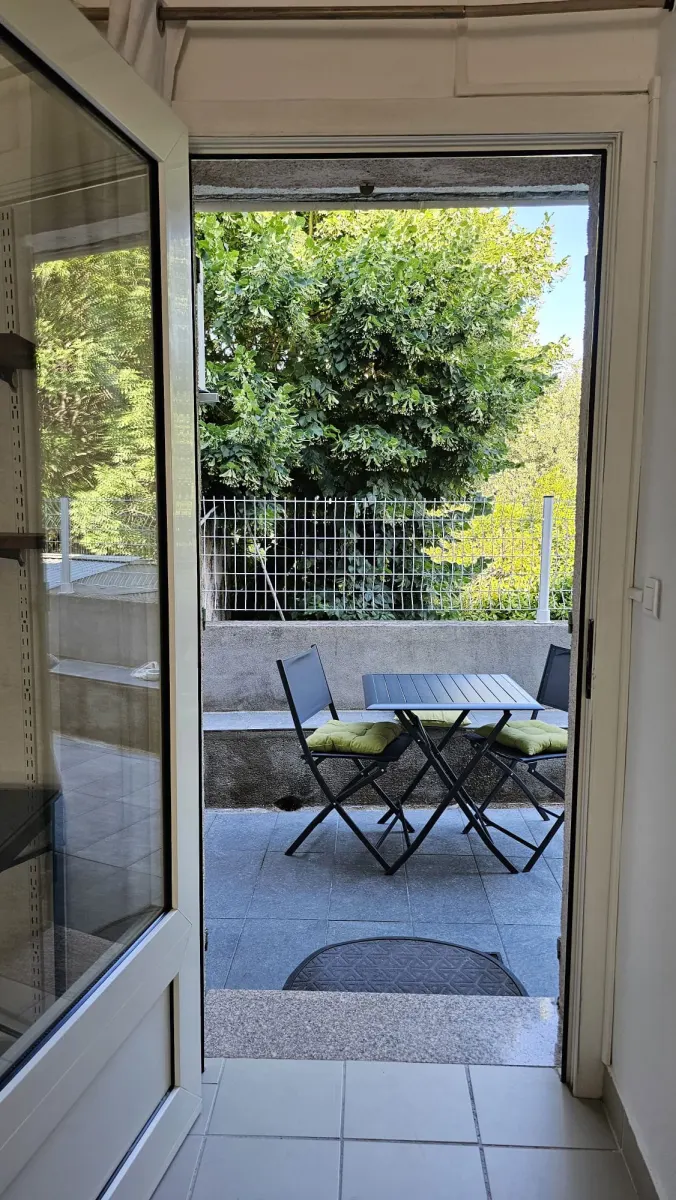 Vue depuis le studio vers la terrasse et les arbres